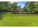 Expansive fenced backyard with brick home, lush lawn, landscaping, and patio area at 1310 Weddington Hills Dr, Matthews, NC 28104