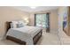 Bright bedroom showcasing a neatly made bed, complemented by neutral walls, and large window at 1310 Weddington Hills Dr, Matthews, NC 28104