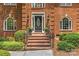 Welcoming brick stairs leading to the front door, framed by elegant landscaping and traditional architectural details at 1310 Weddington Hills Dr, Matthews, NC 28104