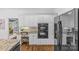 Modern kitchen with white cabinetry, built-in oven and microwave, granite countertops, and hardwood flooring at 1310 Weddington Hills Dr, Matthews, NC 28104