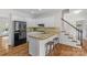 Bright kitchen with granite countertops, wooden floors, a black refrigerator and a breakfast bar with stools at 1310 Weddington Hills Dr, Matthews, NC 28104