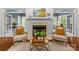 Cozy fireplace with decorative mantle, flanked by chairs and bathed in natural light, creating a warm ambiance at 1310 Weddington Hills Dr, Matthews, NC 28104