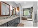 Elegant bathroom showcasing double vanities, mirrors, marble countertops, and a walk-in shower with tub at 1310 Weddington Hills Dr, Matthews, NC 28104
