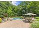 Backyard featuring a swimming pool, lounge chairs, dining area, and lush landscaping at 1310 Weddington Hills Dr, Matthews, NC 28104