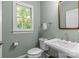 Cozy powder room featuring a white pedestal sink, toilet, window, and fresh paint at 1310 Weddington Hills Dr, Matthews, NC 28104