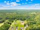 An aerial view of the property showcases its spacious lot, mature trees, and surrounding landscape on a sunny day at 132 Witherspoon Ln, Statesville, NC 28677