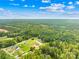 An aerial view shows the property on a large lot with mature trees, nearby homes, and a bright blue sky at 132 Witherspoon Ln, Statesville, NC 28677