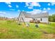 Spacious backyard with a wooden deck, playground, and lush green lawn at 132 Witherspoon Ln, Statesville, NC 28677