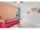 Bright bedroom with pink accent wall, neutral carpet, a window, and decor at 132 Witherspoon Ln, Statesville, NC 28677