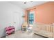 Charming Bedroom with a white crib, rocking chair, and soft, peach-colored walls at 132 Witherspoon Ln, Statesville, NC 28677