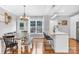Open-concept dining area featuring hardwood floors, ample seating, a modern light fixture, and a large window at 132 Witherspoon Ln, Statesville, NC 28677