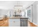 Kitchen island featuring granite countertop, stainless steel dishwasher, lighting, and seamless flow into living and dining areas at 132 Witherspoon Ln, Statesville, NC 28677