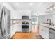 Modern kitchen featuring stainless steel appliances, white cabinetry, granite countertops, and seamless flow to the living area at 132 Witherspoon Ln, Statesville, NC 28677