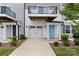 Inviting townhome exterior featuring a bright blue front door, white garage door, and fresh landscaping at 15034 Scoter St, Charlotte, NC 28262