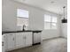 Well-lit kitchen with white cabinets, stainless steel dishwasher, and a sink beneath the windows at 15034 Scoter St, Charlotte, NC 28262