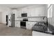 Modern kitchen with white cabinets, black countertops, stainless steel appliances, and sleek fixtures at 15034 Scoter St, Charlotte, NC 28262