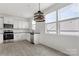 Well-lit kitchen showcases white cabinets, stainless steel appliances, black counters, and an inviting atmosphere at 15034 Scoter St, Charlotte, NC 28262