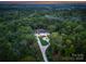 Aerial view of a stunning home nestled within lush greenery with a manicured lawn and a private driveway at 15037 June Washam Rd, Davidson, NC 28036