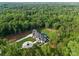A luxury home with a manicured lawn and swimming pool surrounded by a dense forest at 15037 June Washam Rd, Davidson, NC 28036