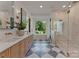 Elegant bathroom featuring double vanity, soaking tub, and glass-enclosed shower at 15037 June Washam Rd, Davidson, NC 28036