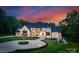 Stunning estate home with lush landscaping, circular driveway, and elegant stone and stucco exterior at 15037 June Washam Rd, Davidson, NC 28036