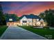 Beautiful luxury home with a three-car garage and a manicured front lawn with landscaped beds at 15037 June Washam Rd, Davidson, NC 28036