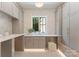 Well-organized laundry room with custom cabinets, counter space, and natural light at 15037 June Washam Rd, Davidson, NC 28036