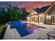Beautiful backyard pool and patio at dusk with outdoor fireplace and entertainment area at 15037 June Washam Rd, Davidson, NC 28036