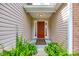 Inviting front entryway featuring a red door, clean lines and mature landscaping at 1520 Deer Forest Dr, Fort Mill, SC 29707