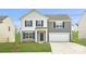 Charming two-story home with a two-car garage, blue shutters, and well-manicured lawn at 1530 Cottage Creek Dr, Bessemer City, NC 28016