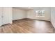 Bright living room with wood-look flooring, a window view, and access to a front door at 1530 Cottage Creek Dr, Bessemer City, NC 28016