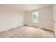 Cozy bedroom featuring neutral carpet, a window offering natural light, and closet space at 1547 Cottage Creek Dr, Bessemer City, NC 28016