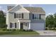 Charming two-story home with sage siding, black shutters, and a two-car garage offers a welcoming curb appeal at 1904 Old Ormand Ln, Bessemer City, NC 28016