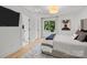 Well-lit bedroom featuring neutral walls, a picture window and a large television at 2121 Laburnum Ave, Charlotte, NC 28205