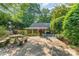 Inviting back patio with a stone picnic table, sun umbrella, and direct access to screened-in porch at 220 Blackberry Trl, Concord, NC 28027