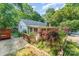 Backyard featuring mature trees, wooden deck, sunroom, and lush landscaping at 220 Blackberry Trl, Concord, NC 28027