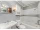 Well-lit bathroom features tiled shower and tub, pedestal sink, and medicine cabinet at 220 Blackberry Trl, Concord, NC 28027
