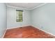 Bedroom with hardwood floors, neutral walls, and a large window for natural light at 220 Blackberry Trl, Concord, NC 28027