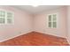 Empty bedroom with hardwood floors and two windows letting in natural light at 220 Blackberry Trl, Concord, NC 28027