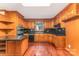 Traditional kitchen features wood cabinets, black tile countertops, and hardwood flooring at 220 Blackberry Trl, Concord, NC 28027