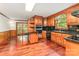 Traditional kitchen features wood cabinets, black tile countertops, and hardwood flooring at 220 Blackberry Trl, Concord, NC 28027