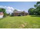 Expansive backyard with a charming brick house featuring a covered deck and fenced perimeter at 233 Reliance Rd, Kings Mountain, NC 28086