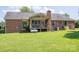 Lush backyard showcases a brick house with a covered deck perfect for outdoor entertaining and relaxation at 233 Reliance Rd, Kings Mountain, NC 28086
