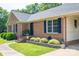 Charming brick home featuring a covered carport, manicured landscaping, and classic blue shutters at 233 Reliance Rd, Kings Mountain, NC 28086