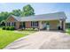 Well-maintained brick home featuring a convenient carport, basketball hoop, and beautifully landscaped front yard at 233 Reliance Rd, Kings Mountain, NC 28086