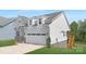 This is a view of the rear, featuring light blue siding, stone accents, and a wooden staircase at 24578 Blue Heron Cir # 407, Lancaster, SC 29720