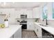 Bright kitchen features white cabinets, stainless steel appliances, and a large window at 24578 Blue Heron Cir # 407, Lancaster, SC 29720