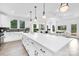 Spacious open kitchen with white cabinets, stainless appliances, large island with seating, and lots of natural light at 24578 Blue Heron Cir # 407, Lancaster, SC 29720