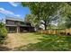 Large backyard with a spacious lawn, tall fence, and the back of the home in the background at 2921 Windsor Ave, Charlotte, NC 28209
