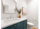 Modern bathroom features a navy vanity, marble countertop, gold hardware and modern fixtures at 2921 Windsor Ave, Charlotte, NC 28209